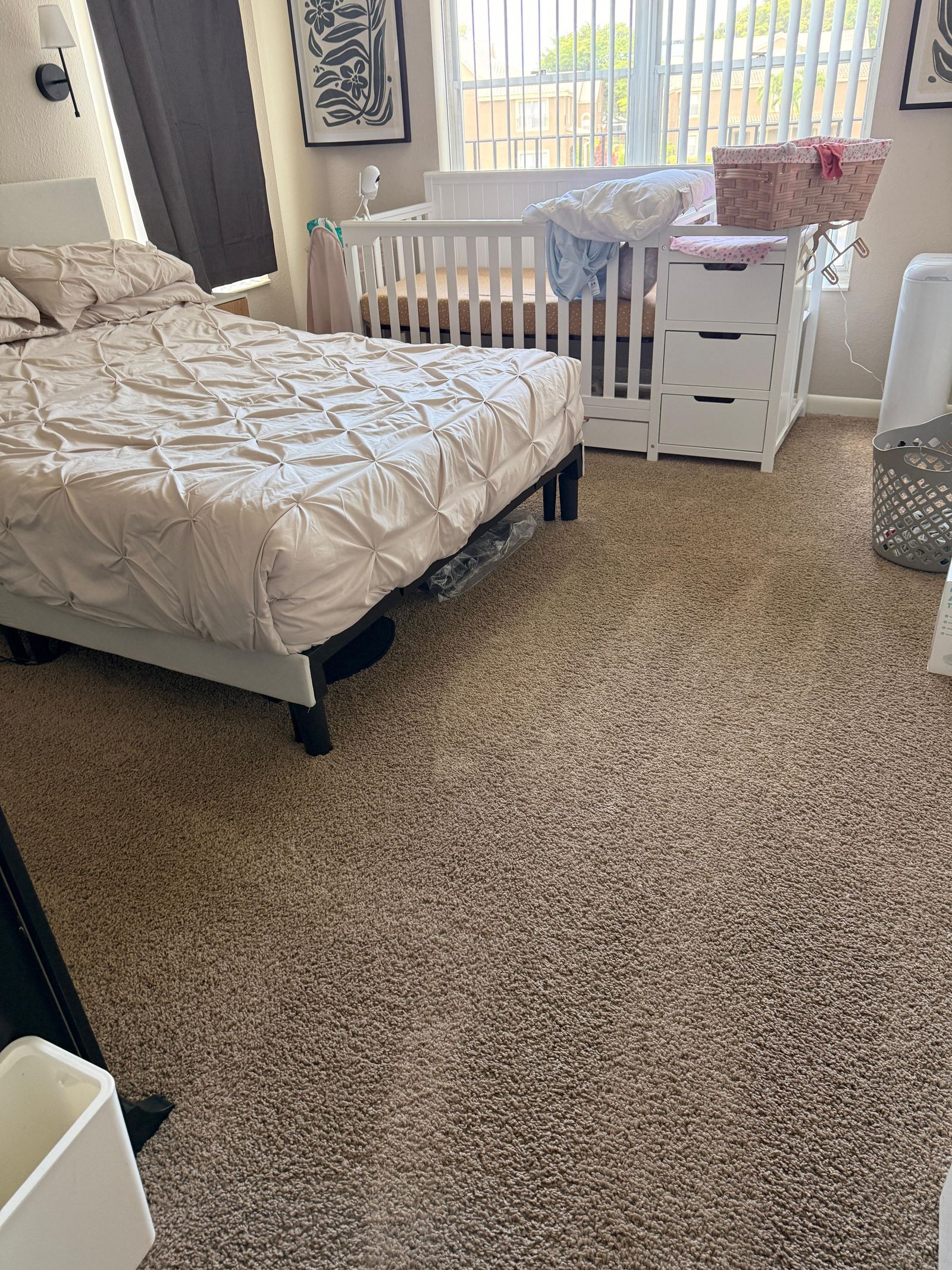 Freshly made bed and vacuumed carpet in a cleaned bedroom